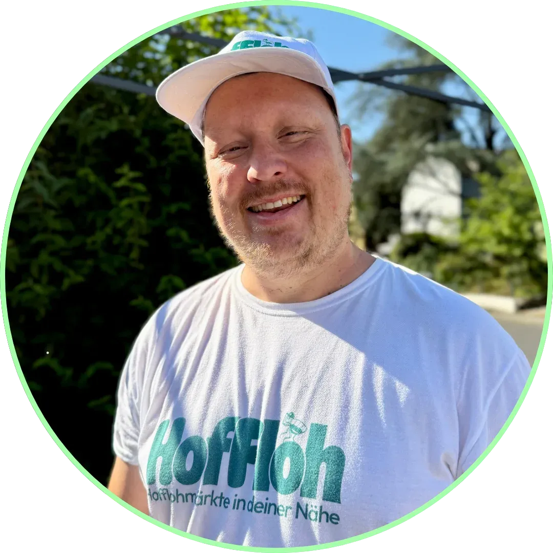 Martin Müller, Co-Gründer von HofFloh, lächelnd mit weißer Kappe und HofFloh-T-Shirt